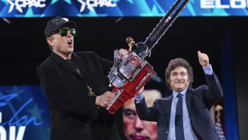 Elon Musk, left, receives a chainsaw from Argentina's President Javier Milei as they arrive speaks at the Conservative Political Action Conference, CPAC, at the Gaylord National Resort & Convention Center, Thursday, Feb. 20, 2025, in Oxon Hill, Md. (AP Photo/Jose Luis Magana)