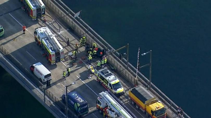 A person is trapped in a crushed car after a collision with a truck.