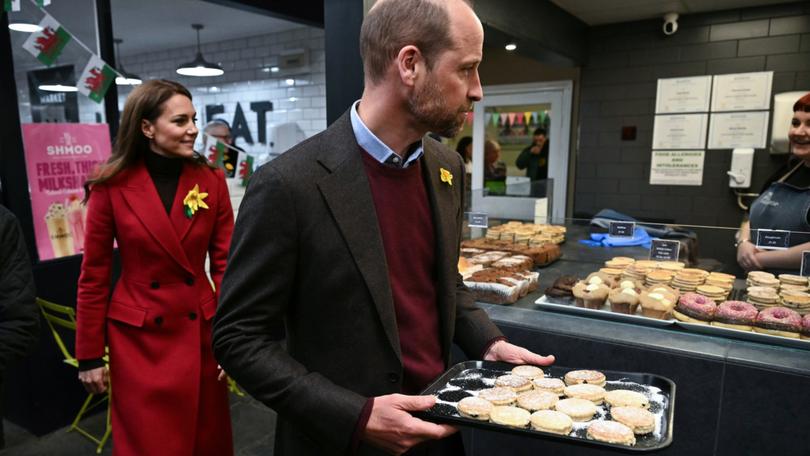 Prince William, Prince of Wales and Catherine, Princess of Wales distribute to Welsh Cakes during a visit to Pontypridd