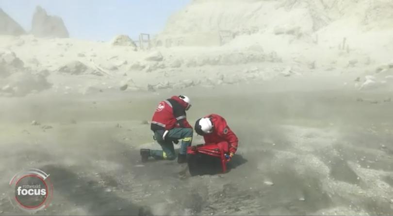 Rescuers shelter from the ash.  