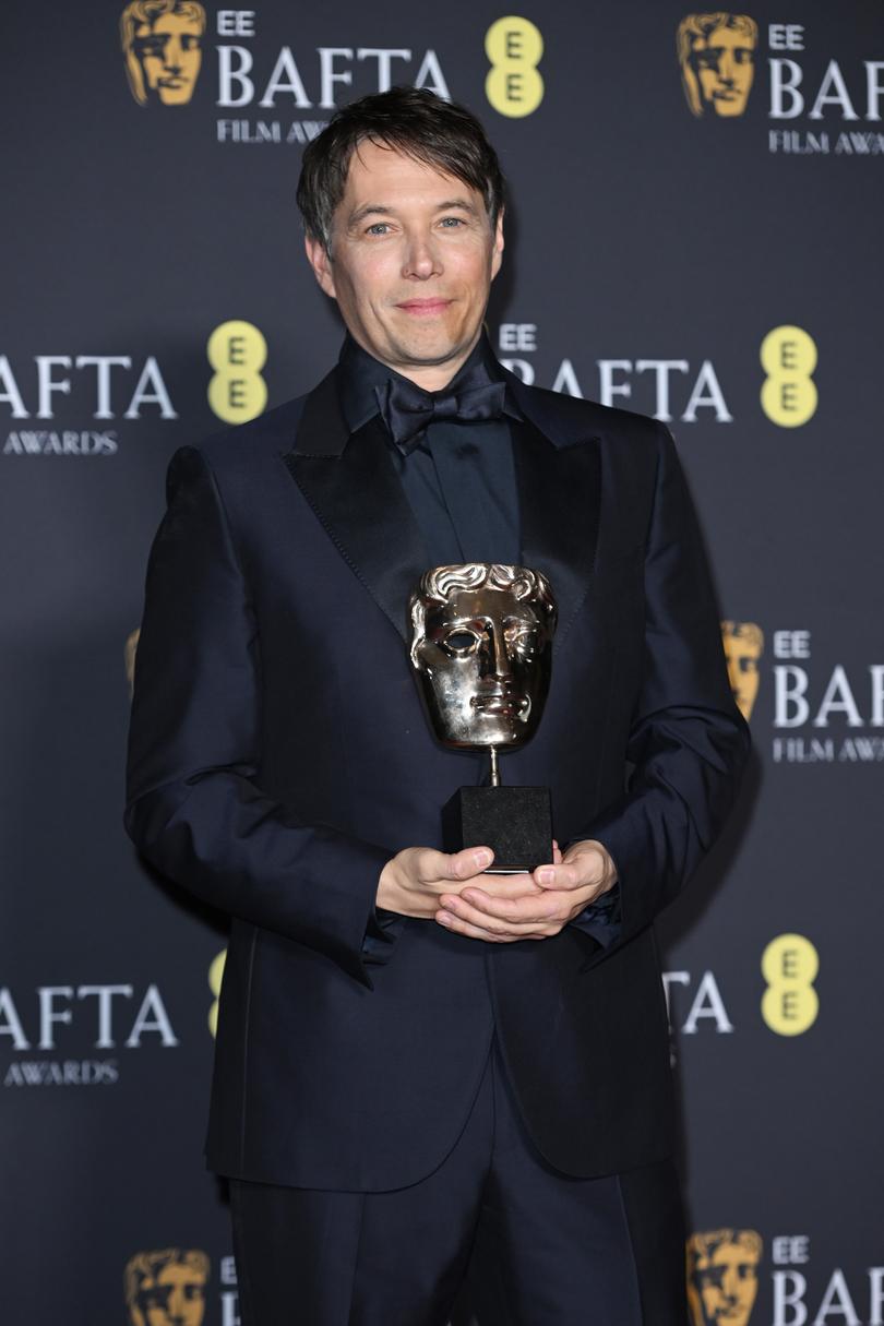 Sean Baker poses with the BAFTAs Casting Award for Anora.