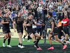 Daine Laurie celebrates with teammates after scoring the match-winning try.