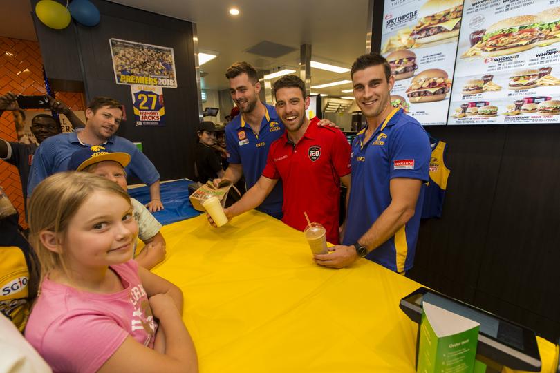 West Coast player Elliot Yeo, Eagles WAFL player Fraser McInnes (beard) and a Perth WAFL player Corey Yeo (red shirt) meeting fans at Hungry Jack's store in Cannington.