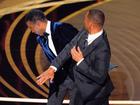 Will Smith, right, hits presenter Chris Rock on stage while presenting the award for best documentary feature at the Oscars.