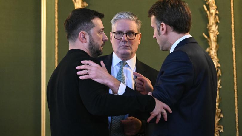 Ukraine's President Volodymyr Zelensky, Britain's Prime Minister Keir Starmer and France's President Emmanuel Macron embrace during the summit at Lancaster House/