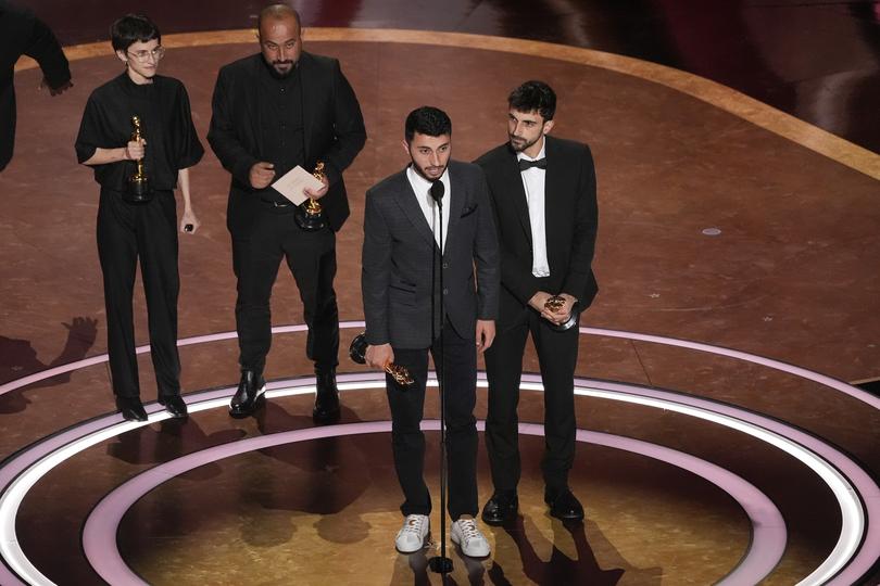 Rachel Szor, from left, Hamdan Ballal, Basel Adra, and Yuval Abraham accept the award for best documentary feature film for No Other Land during the Oscars in Los Angeles.