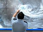 Members of the SES inspect Tropical Cyclone Alfred on the Bureau of Meteorology satellite view at the NSW SES Rhodes Headquarters in Sydney.