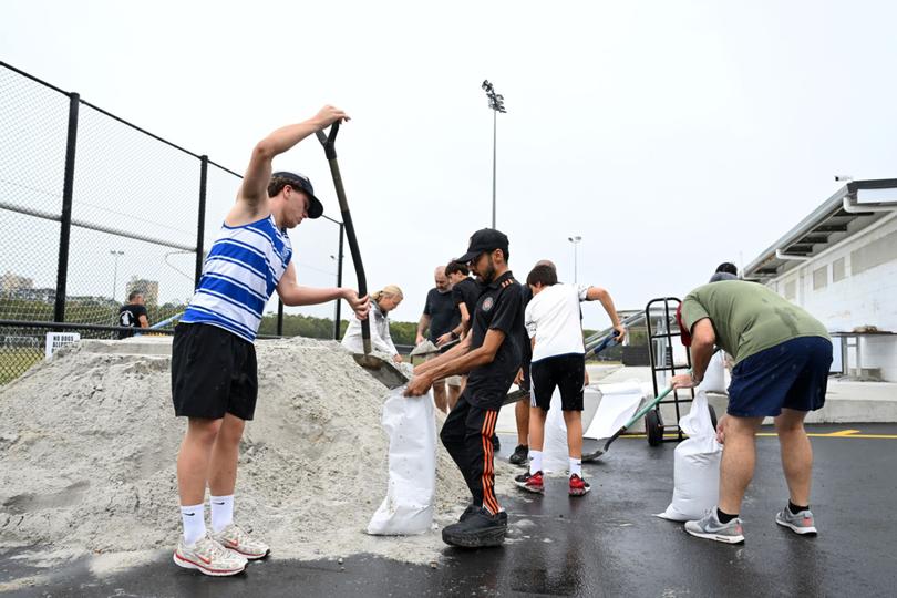 Members of Eastern Suburbs Soccer Club fill sandbags at Heath Park on March 05, 2025 in Brisbane, Australia.