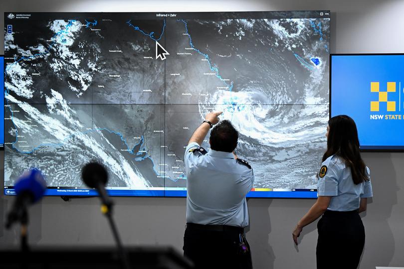 Members of the SES inspect Tropical Cyclone Alfred on the Bureau of Meteorology (BOM) satellite view at the NSW SES Rhodes Headquarters in Sydney, Wednesday, March 5, 2025. (AAP Image/Bianca De Marchi) NO ARCHIVING BIANCA DE MARCHI