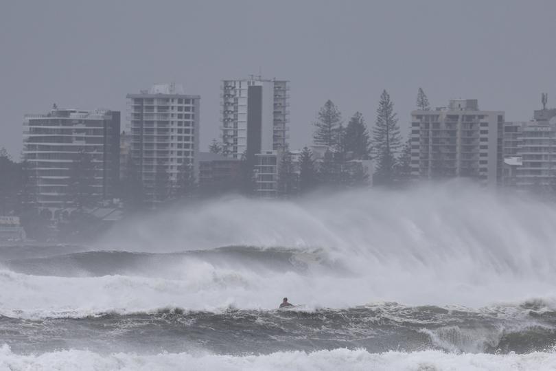 A person riding a jet ski attempts to tow surfboard riders amid record-breaking waves as the outer fringe of Tropical Cyclone Alfred started whipping eastern Australia, in Coolangatta on March 6, 2025.