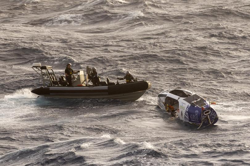 In this photo provided by the Australian Defense Force Australian Navy sailors from HMAS Choules use an inflatable boat to rescue Lithuanian rower Aurimas Mockus, Monday, March 3, 2025, who struck a storm in the Coral Sea off the northeast coast of Australia while attempting to cross the Pacific Ocean from California. (CPOIS Helen Frank/Australian Defense Force via AP)