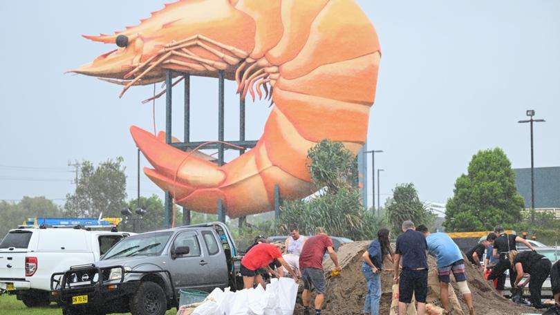 People fill up DIY sandbags beside the Big Prawn ahead of cyclonic conditions in Ballina, NSW.