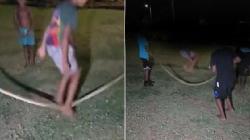 The youths were filmed laughing and jumping over the black-headed python on Wednesday night.