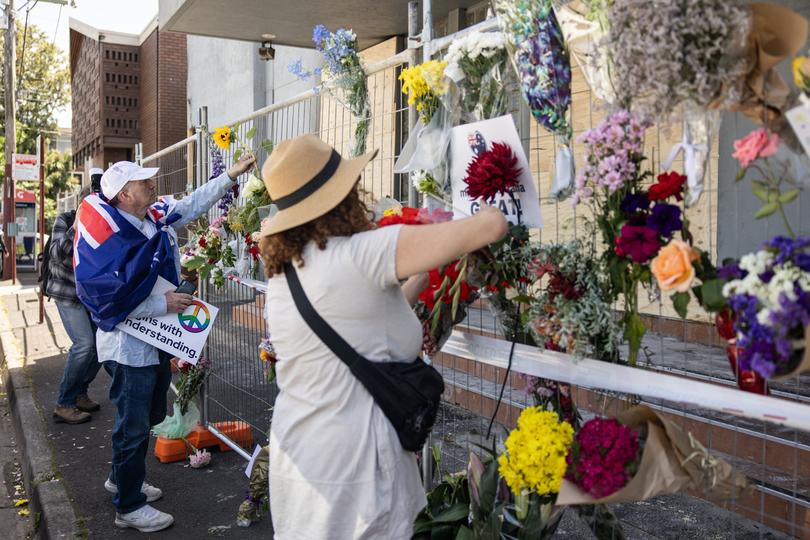 People bring floral tribute at the scene of a fire at the Adass Israel Synagogue in Ripponlea, Melbourne, Sunday, December 8, 2024. 