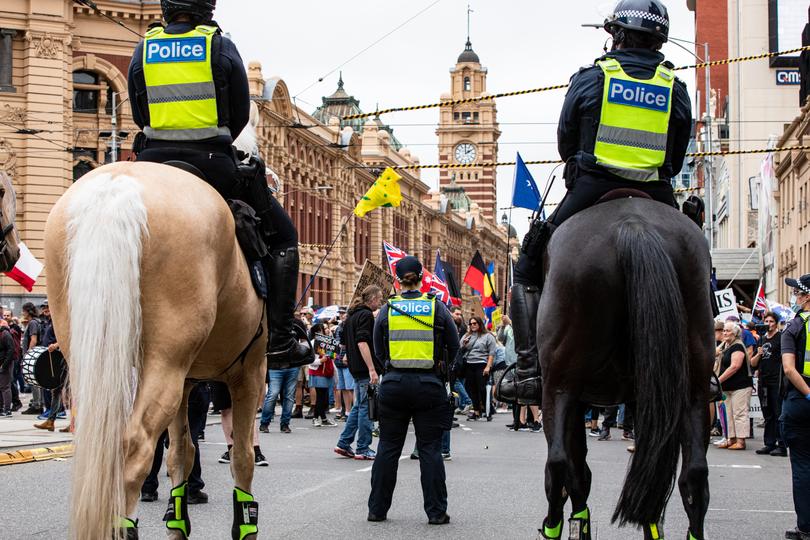 Mounted Police officers patrol Flinders Street as anti-vaccine protesters rally on January 8, 2022.