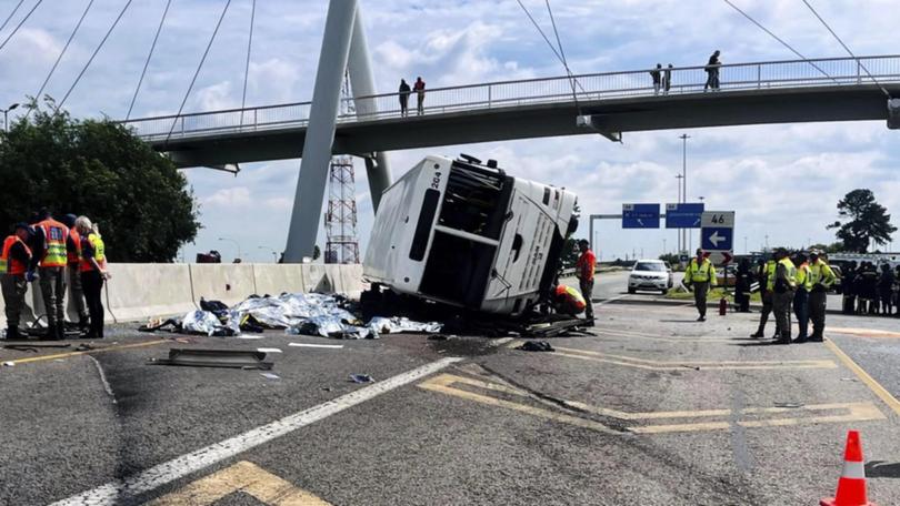 Some passengers were thrown out of a bus when it overturned in Johannesburg, officials say. (AP PHOTO)