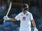 Sam Konstas raises his bat after reaching his half-century against WA. 