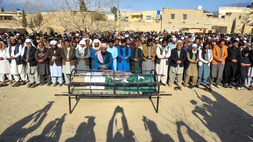 Residents offer funeral prayers for a railwayman killed by armed militants who ambushed a train in the remote mountainous area of Balochistan province, in Quetta. The bodies of at least 25 people, including 21 hostages, killed in a train siege by separatist gunmen in Pakistan were retrieved from the site on March 13 ahead of the first funerals.