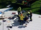 A light plane has crashed into the roof of a building near Sydney, leaving a pilot trapped in the wreckage as emergency services use a cherry picker to reach the man. 7NEWS