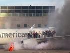 This image courtesy of Branden Williams shows passengers standing on the wing of an American Airlines plane as they are evacuated after it caught fire.