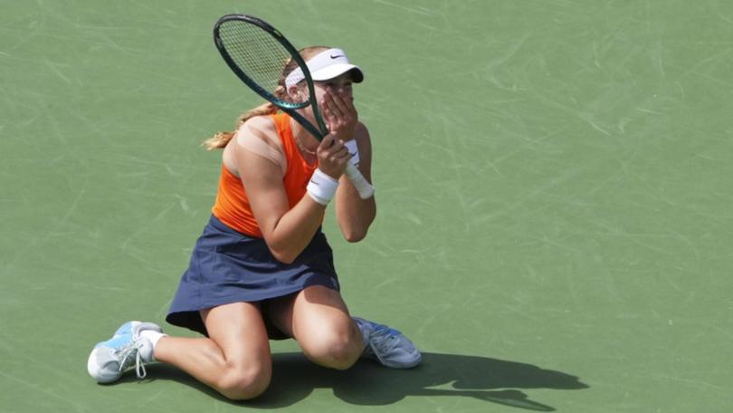 Mirra Andreeva sinks to her knees after claiming the singles title at Indian Wells.