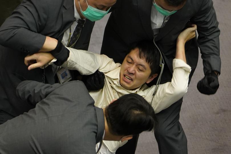 Ted Hui is removed by security officers during scuffles between pro-establishment and opposition lawmakers in the Legislative Council in Hong Kong in May, 2020. 