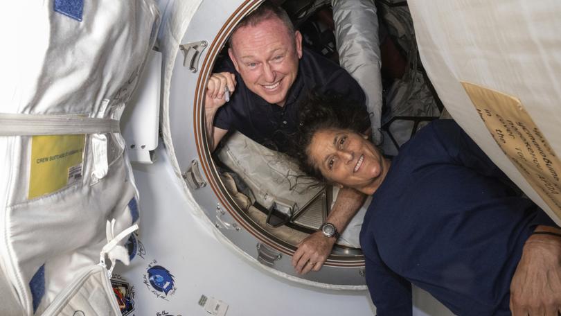 Butch Wilmore and Suni Williams pose for a portrait inside the vestibule between the forward port on the International Space Station's Harmony module and Boeing's Starliner spacecraft on June 13, 2024.