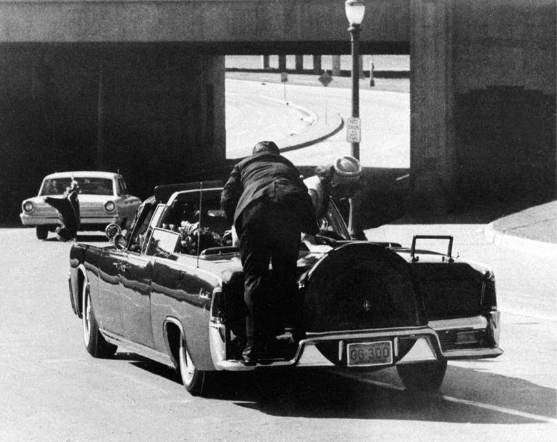 President John F. Kennedy slumps down in the back seat of a car after being fatally shot in Dallas.