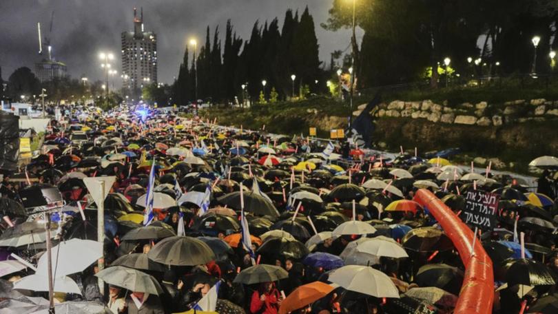 In the rain, Israelis rallied against Benjamin Netanyahu's plan to dismiss the head of Shin Bet. (AP PHOTO)