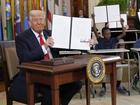 President Donald Trump holds up a signed executive order in the East Room of the White House in Washington, Thursday, March 20, 2025.