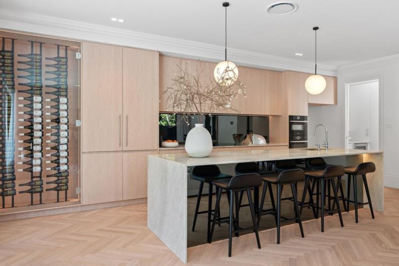 The kitchen features Taj Mahal Quartzite benchtops, a butlers pantry and a 63-bottle wine hold.