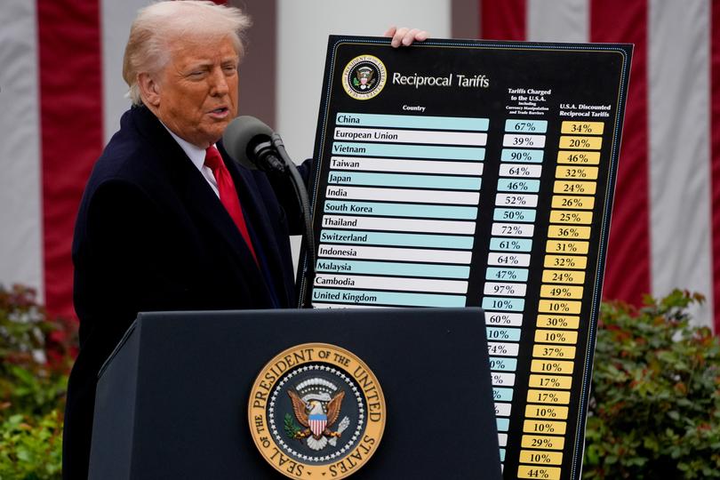 US President Donald Trump holds a reciprocal tariffs poster during a tariff announcement in the Rose Garden of the White House.
