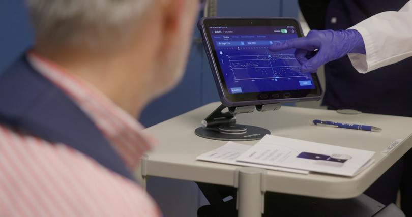 Bronte-Stewart shows Krehbiel how the adaptive deep brain stimulator is streaming in real time both his brain signals and the responding DBS amplitude, at the Stanford School of Medicine.