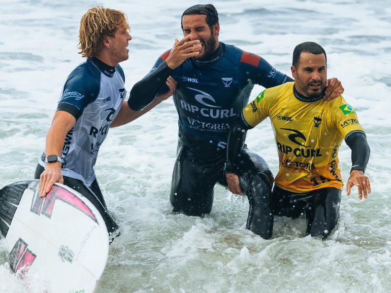 Ramzi Boukhiam is helped out of the water by Xavier Huxtable (left) and Italo Ferreira. (HANDOUT/World Surf League)