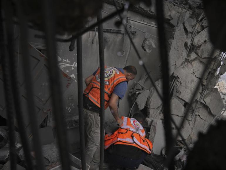 Rescuers searched through debris following an Israeli air strike on a building in Gaza City. (AP PHOTO)