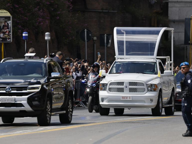 People gather along the road as the coffin of late Pope Francis is transported from St Peter's Basilica to Santa Maria Maggiore Basilica.