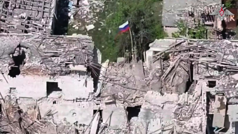 Russian soldier plant a flag in Ukraine’s Kharkiv region on Monday.