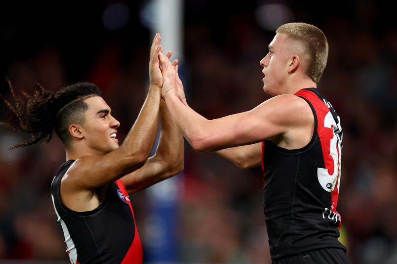 Nate Caddy is congratulated by Isaac Kako after kicking a goal.