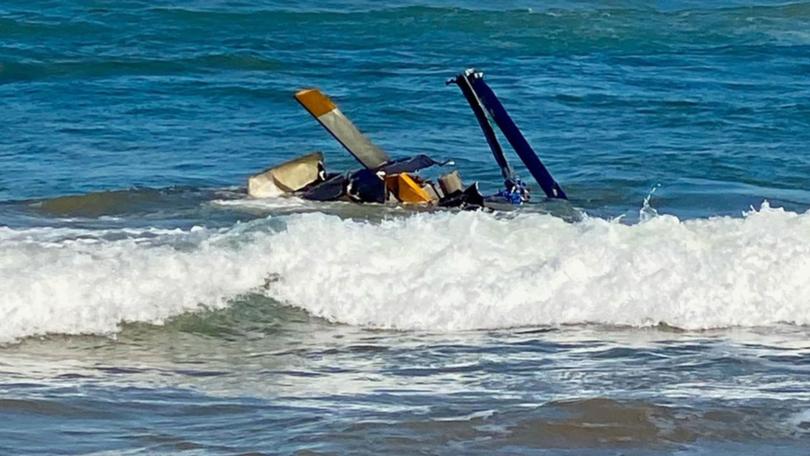 Rescuers pulled three people out of a helicopter which crashed near the shore of a seaside town. (Amenah McDonald/AAP PHOTOS)