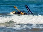 Rescuers pulled three people out of a helicopter which crashed near the shore of a seaside town. (Amenah McDonald/AAP PHOTOS)