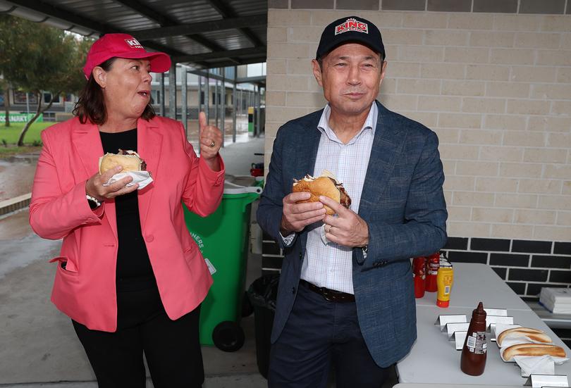 WA Premier Roger Cook and Brand Labor candidate Madeleine King have voted at Wellard Primary School. PIctured - the Premier and Ms King get into a bacon and egg roll