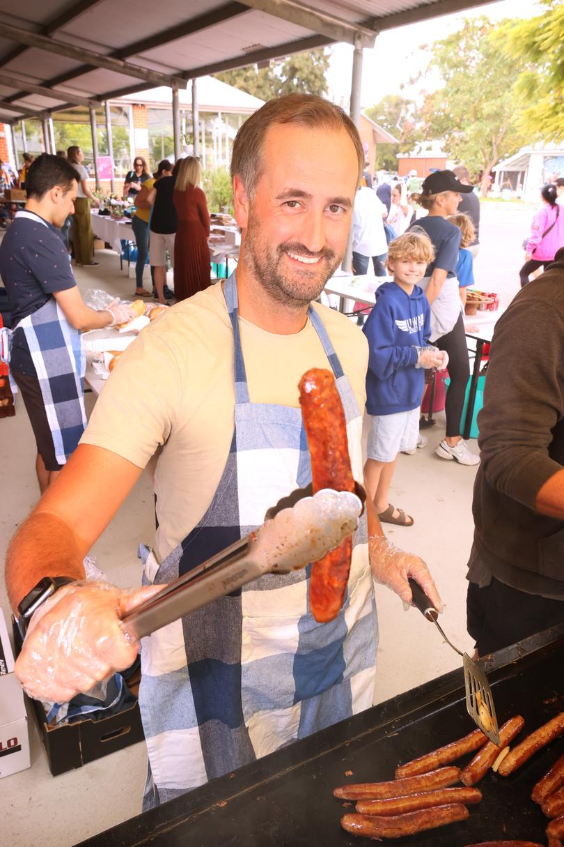 Volunteer Martyn Buffham cooking sausages at Freshwater Bay Primary School in Claremont.