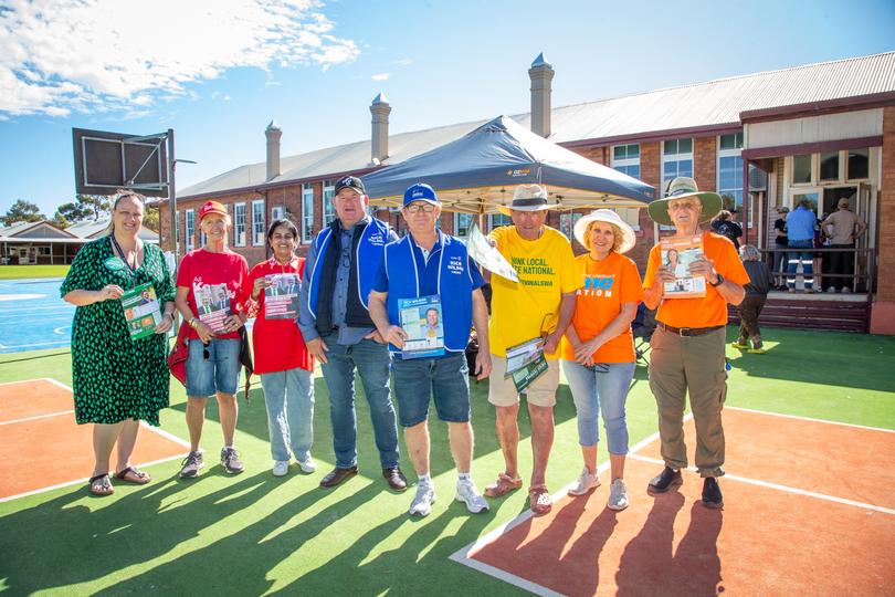 Party supporters hand out how-to-vote cards outside North Kalgoorlie Primary School polling place. 