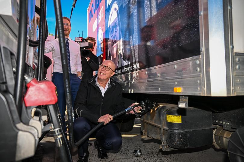Opposition Leader Peter Dutton fills fuel into a truck from a fuel bowser with Senator James Patterson at a petrol station in the electorate of Gorton on May 03, 2025 in the outer western suburbs in Melbourne, Australia.