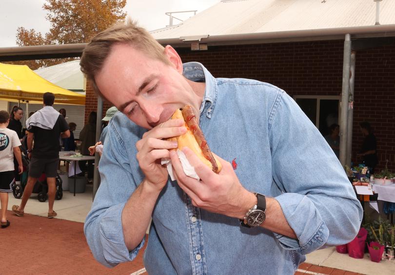 Liberal candidate for Curtin Tom White enjoys a democracy sausage at Freshwater Bay Primary School in Claremont.