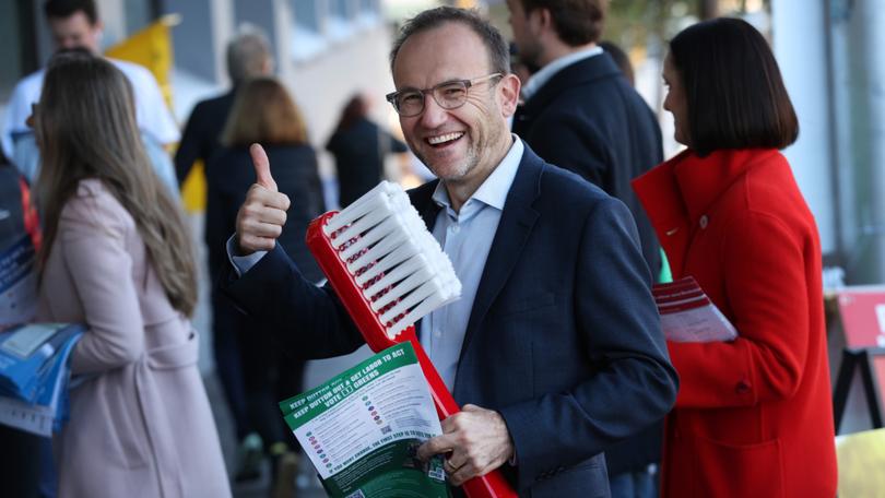 Greens Leader Adam Bandt holds a giant toothbrush to promote dental in Medicare.