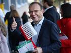 Greens Leader Adam Bandt holds a giant toothbrush to promote dental in Medicare.