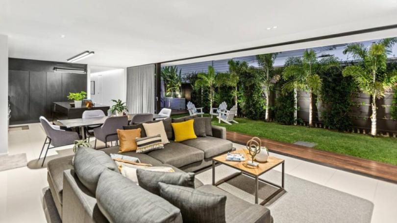 An open-plan living, dining and kitchen area features a monochromatic colour palette.