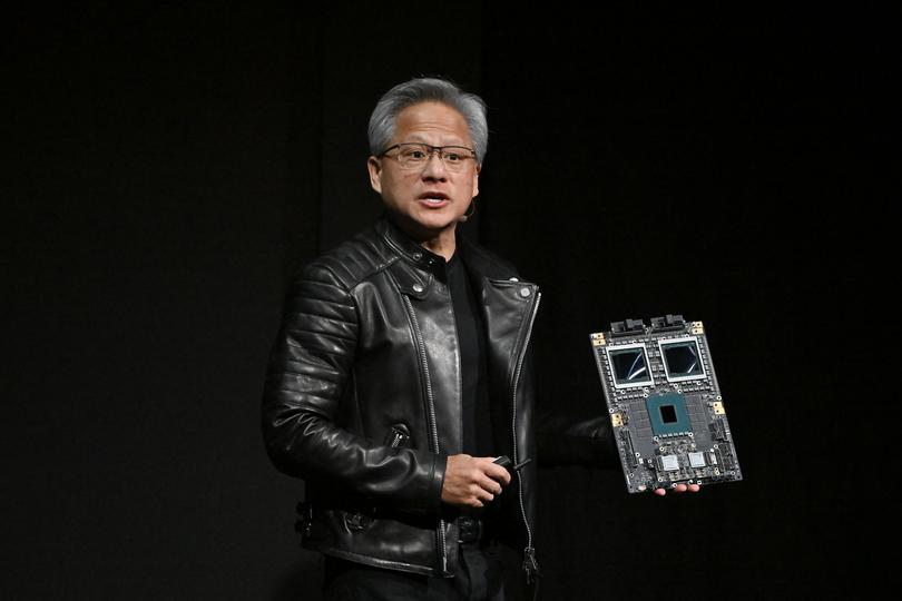 Jensen Huang, co-founder and chief executive officer of Nvidia Corp., holds up the company's AI accelerator chips for data centres as he speaks during the Nvidia AI Summit Japan in Tokyo, last year.