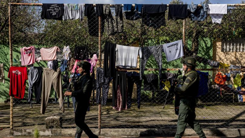 FILE — Police patrol next to clotheslines in Tibu, a small town near the border with Venezuela, in Colombia, Jan. 22, 2025. People displaced by violence in the region had taken shelter in the town. (Federico Rios/The New York Times)